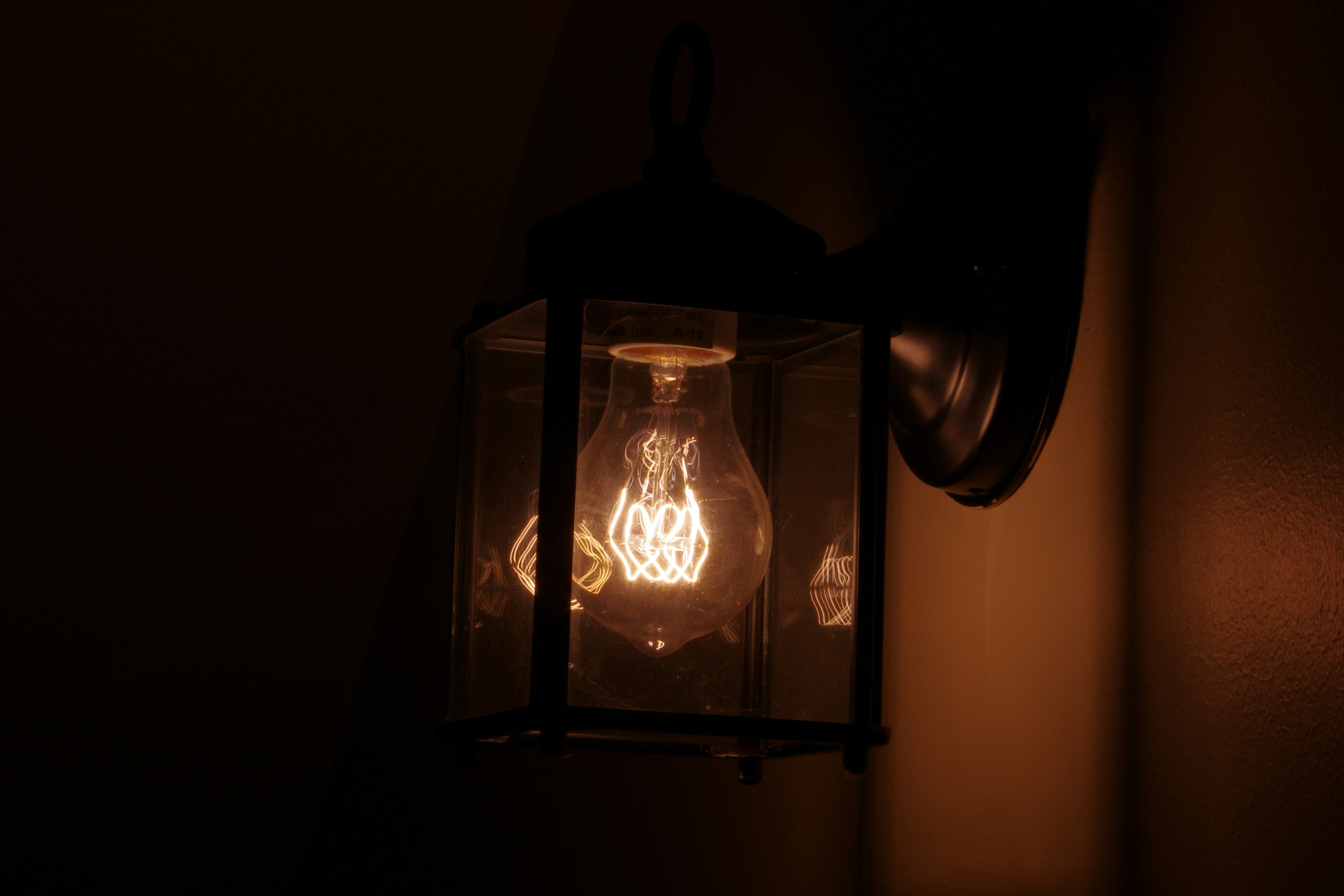 Dark moody photograph centered on a lit bulb.